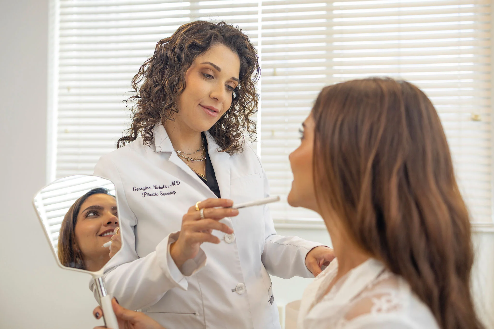 Dr. Georgina Nichols examining a patient with a handheld mirror